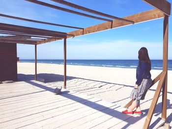 Woman looking at sea against sky