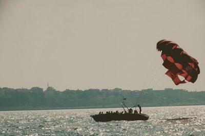 Man on boat in sea against clear sky