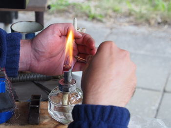 Close-up of man hands shielding oil lamp