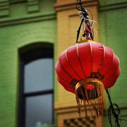 Close-up of red bell hanging against building