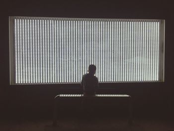 Silhouette man sitting on floor