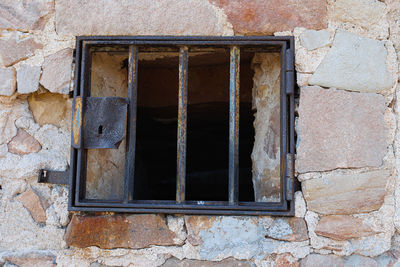 Small rusty iron window with bars in montjuic castle in barcelona, spain.