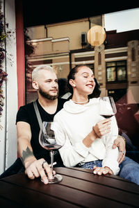 Young man and woman sitting on table