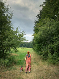 Rear view of woman with dog on field