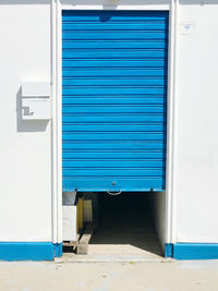 Closed and open blue door of building