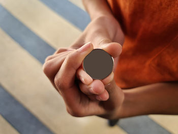 High angle view of boy holding a gray isolated face coin