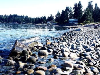 Stones in sea against sky