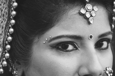 Cropped portrait of indian bride wearing jewelry during wedding