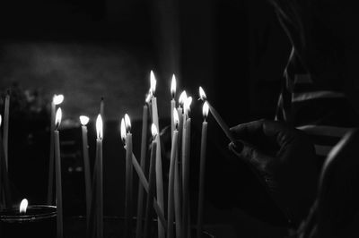 Cropped hand burning candles in church