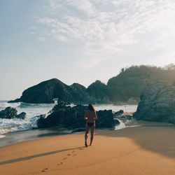 Rear view of woman standing on beach