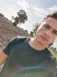 Portrait of young man against sky