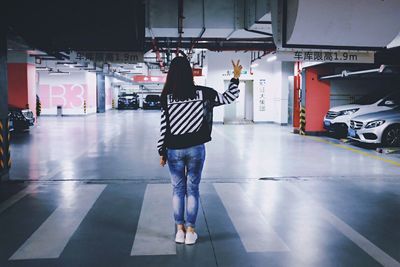 Full length of young woman standing by railing