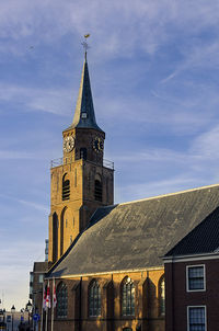 Low angle view of clock tower against cloudy sky