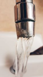 Close-up of water faucet in glass container