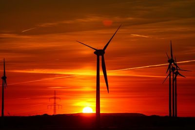 Low angle view of silhouette windmill against sky during sunset