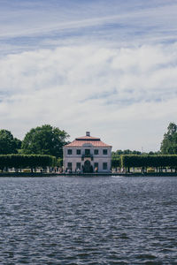 Scenic view of river by buildings against sky