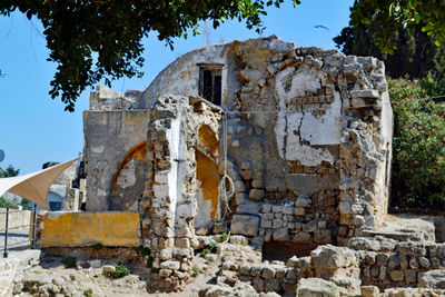 Old ruins by building against sky