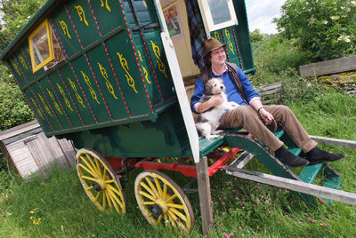 Portrait of man with dog sitting on grass