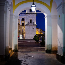 Illuminated street amidst buildings in city at night