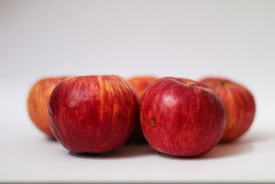 Close-up of apples on table against white background