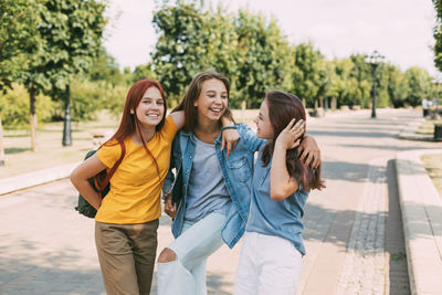 Three cheerful teenage girls schoolgirls coming from school. the concept of training and education