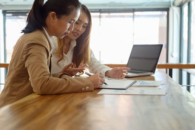 Colleagues working over graph in office