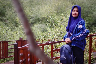 Portrait of woman against railing