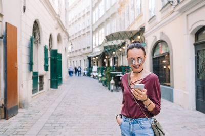 Portrait of young woman standing in city