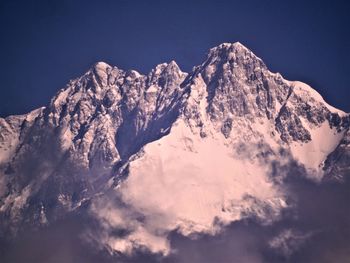 Low angle view of snowcapped mountains against sky