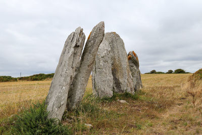 Stone wall on field against sky