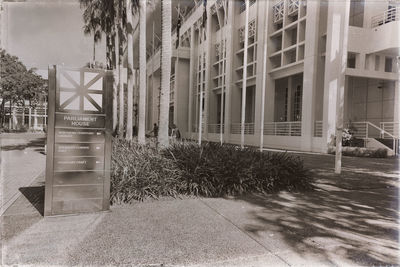 Empty footpath by buildings in city