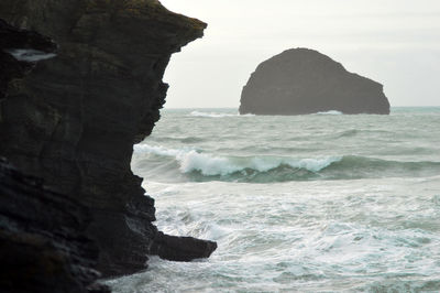 Scenic view of rocks in sea against sky