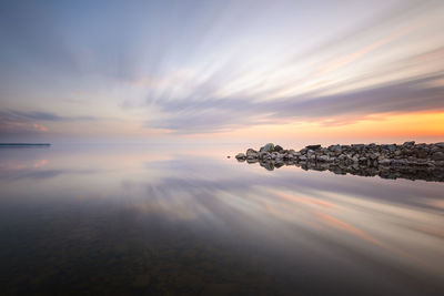 Reflections in water of pier and sunset sky, sweden