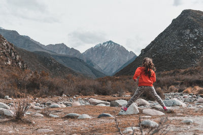 Girl jumping rocks in mountainous area