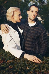 Couple standing in park against trees