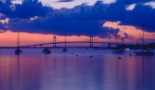 Sailboats in sea against sky during sunset