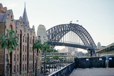 Buildings by sydney harbor bridge against clear sky