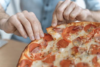 Midsection of man preparing pizza