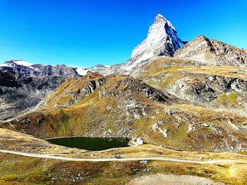 Scenic view of snowcapped mountains against clear blue sky