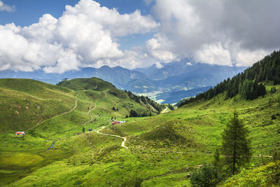 Scenic view of green landscape and mountains against sky