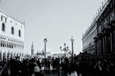 People on street against buildings in city