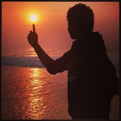 Man photographing sea at sunset