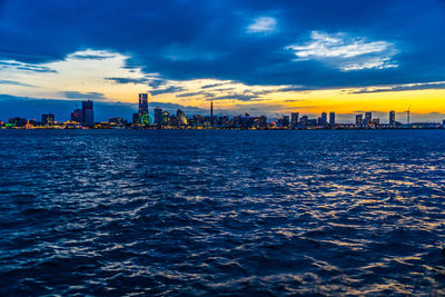 View of sea and buildings against sky during sunset