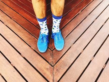 Low section of man standing on hardwood floor