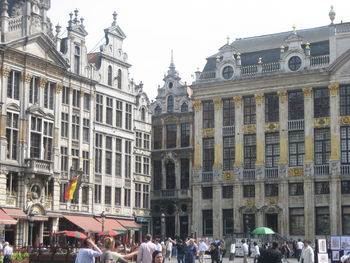 People on street against buildings in city