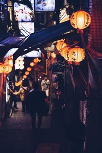 People in illuminated market at night