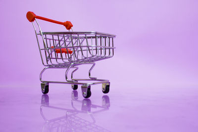 Side view of a pink glass on table against colored background