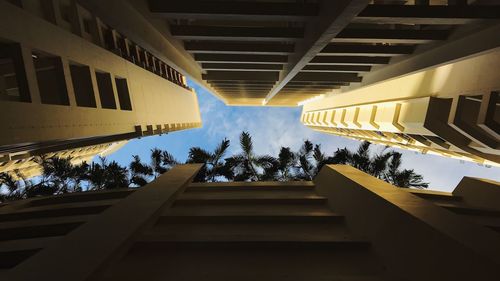 Low angle view of steps amidst buildings against sky