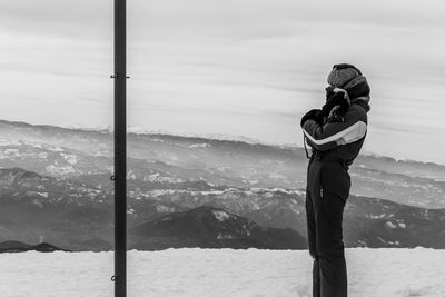 Woman standing on snow covered mountain