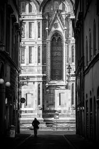Man walking on road along buildings